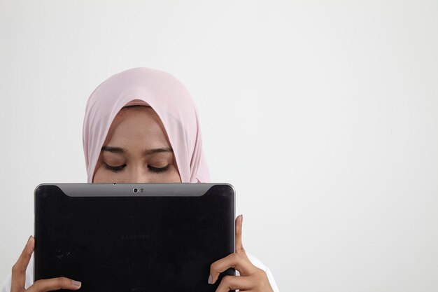 Portrait of young woman using smart phone against white background