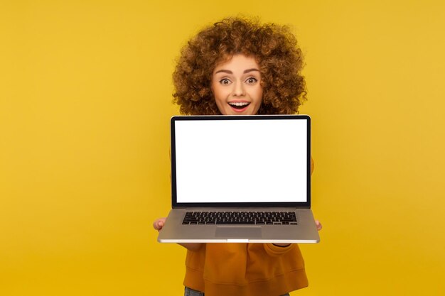 Portrait of young woman using smart phone against yellow background