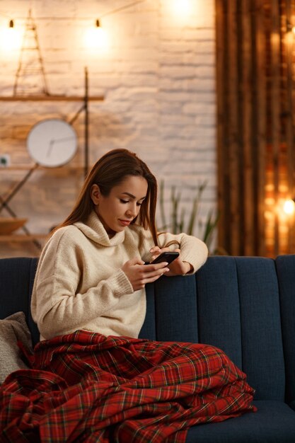 Portrait of young woman using smartphone and smiling