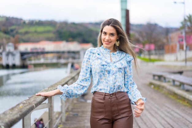 Portrait of young woman walking along the river in the city lifestyle concept blue shirt