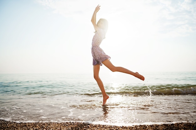 Portrait of young woman walking on the beach on sunrise