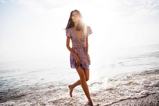 Portrait of young woman walking on the beach on sunrise