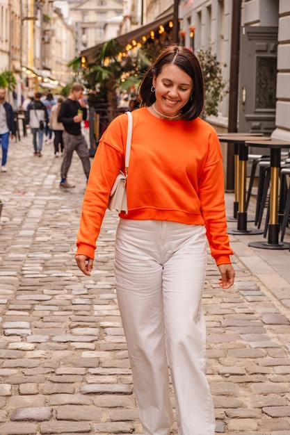 Portrait of young woman walking on footpath