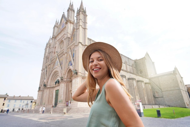 Portrait of young woman walking in Orvieto with the Cathedral on the background Umbria Italy