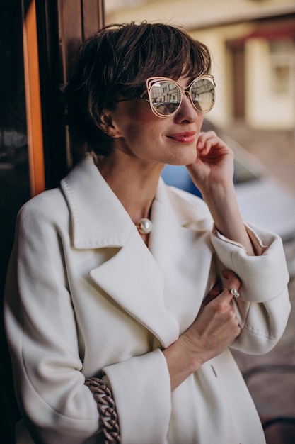 Portrait of young woman walking out of the doors in some cafe