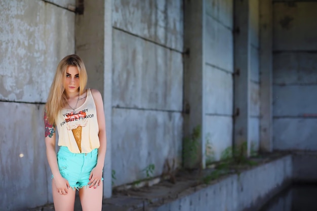 Portrait of Young Woman on Wall Background. Trendy Urban Fashion Concept. Outdoor closeup fashion portrait of young sexy crazy girl