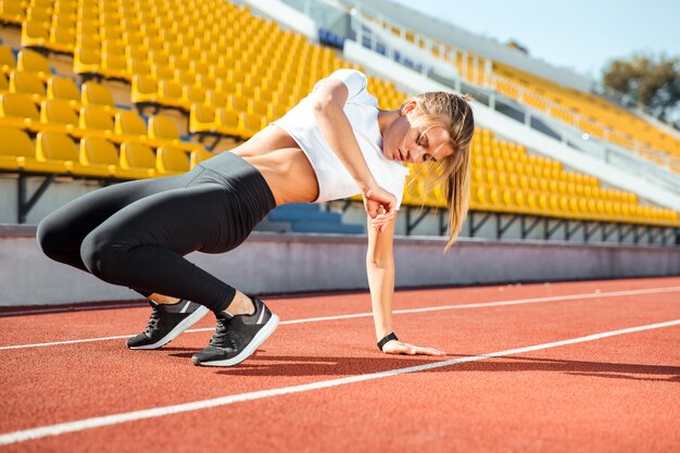 Portrait of a young woman warming up at stadium