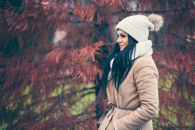 Foto ritratto di una giovane donna che indossa un cappotto e un cappello