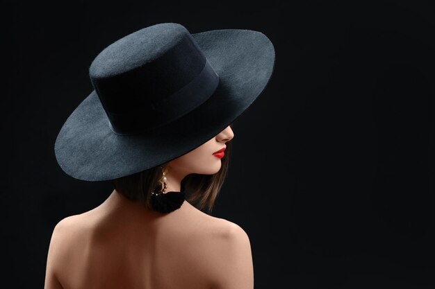 Photo portrait of young woman wearing hat against black background