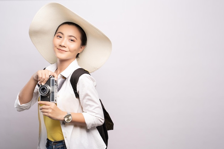 Photo 白い背景に写真を撮っているときに帽子をかぶった若い女性の肖像画