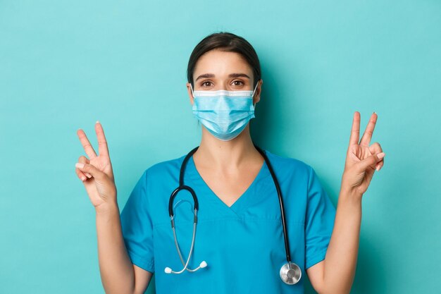 Portrait of young woman wearing mask against blue background