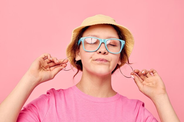 Portrait of a young woman wearing a panama hat and glasses posing