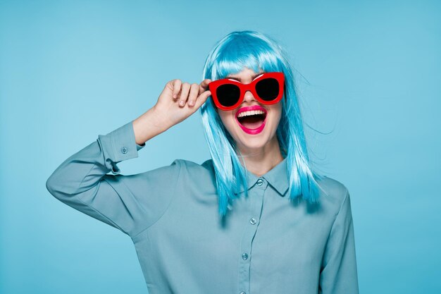 Photo portrait of young woman wearing sunglasses against blue background