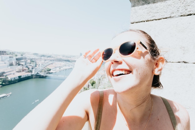 Portrait of young woman wearing sunglasses against sea