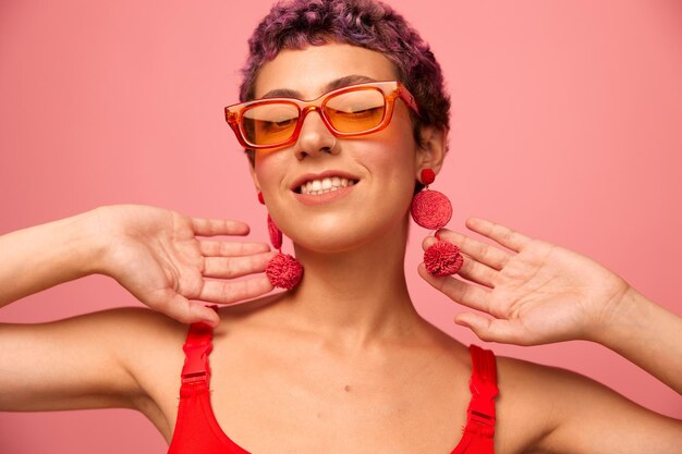 Portrait of young woman wearing sunglasses against yellow background