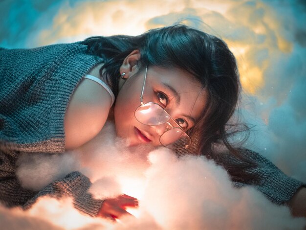 Photo portrait of young woman wearing sunglasses lying on fur