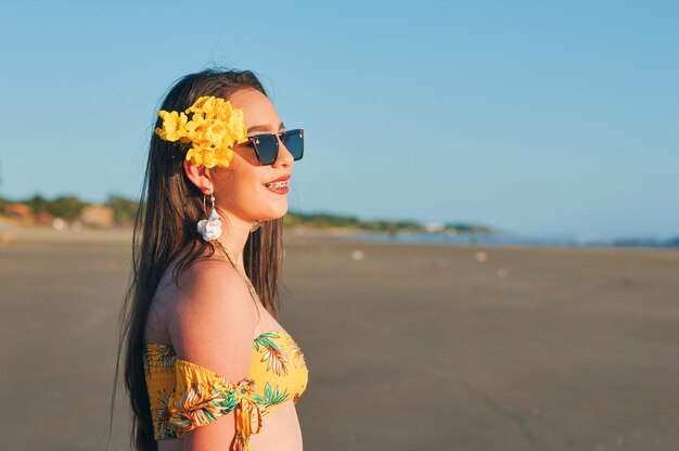 Portrait of young woman wearing sunglasses standing on beach