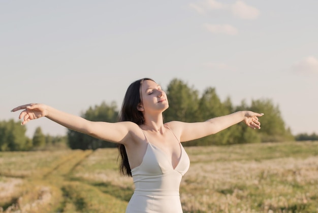 Ritratto di giovane donna in abito bianco all'aperto