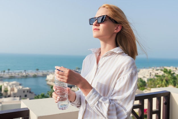 Portrait of a young woman who drinks water on a hot day