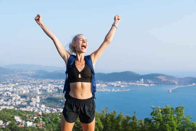 Portrait of a young woman who is happy that she climbed the mountain Beautiful sea view Hiking in summer