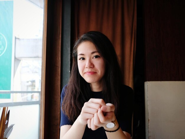 Photo portrait of young woman next to window