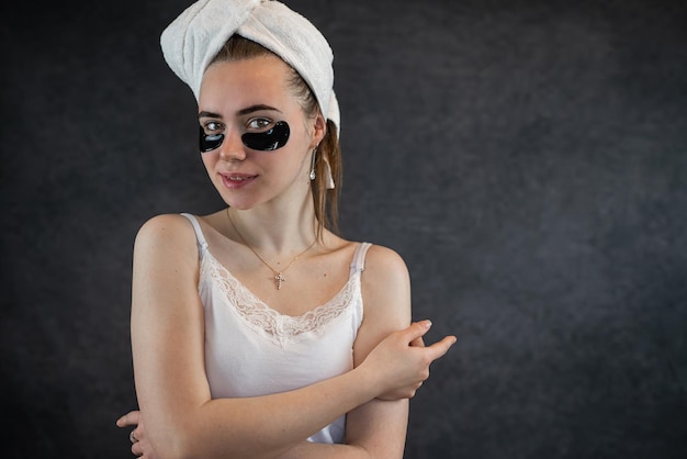 Portrait of young woman with applied black beauty patches isolated on black background