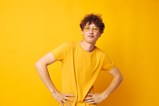 Portrait of young woman with arms crossed against yellow background