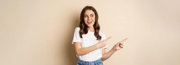 Photo portrait of young woman with arms crossed standing against gray background