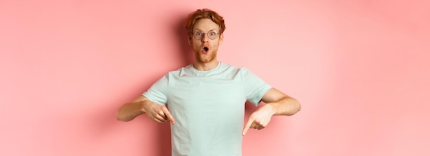 Portrait of young woman with arms crossed standing against pink background