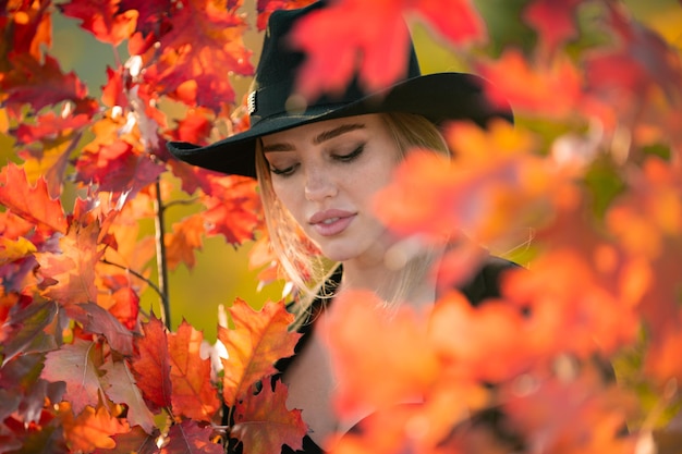 Portrait of young woman with autumn leafs romantic girl dream hold fall maple leaves autumnal season