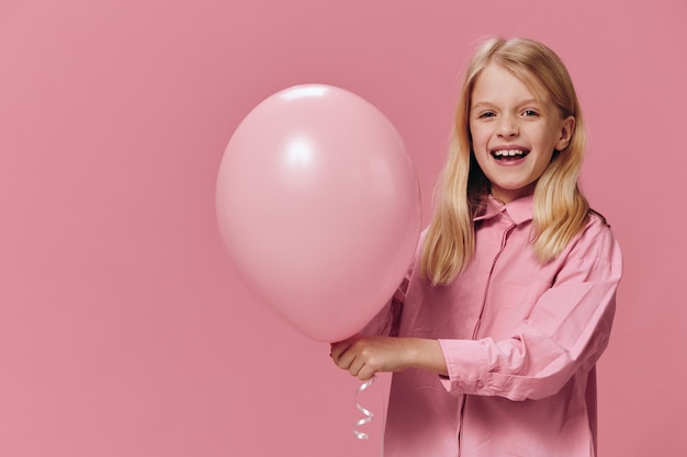 Портрет молодой женщины с воздушными шарами на розовом фоне