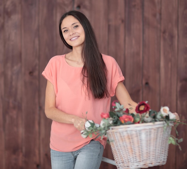 バスケットに自転車と春の花を持つ若い女性の肖像画