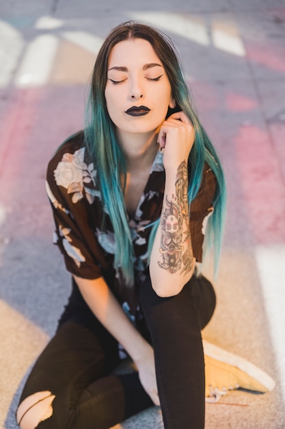 Photo portrait of a young woman with black lips closing her eyes