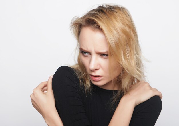 Portrait of a young woman with blond hair in a black shirt on a white background A woman without makeup Model test Fashion model