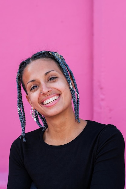 Portrait of young woman with braids and urban style outdoors