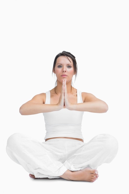 Portrait of young woman with crossed legs in praying position