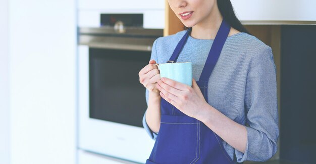 キッチンのインテリアの背景にカップと若い女性の肖像画