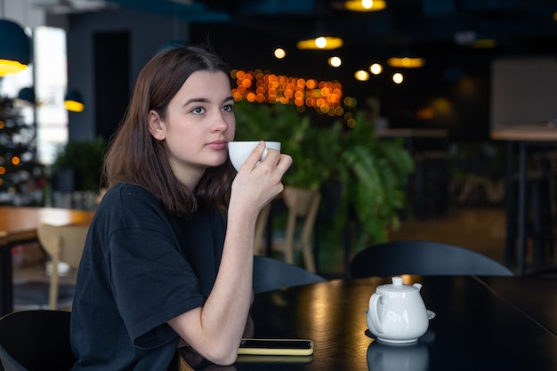 Ritratto di una giovane donna con una tazza di tè in un caffè