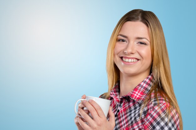 Portrait of a young woman with cup of tea or coffee