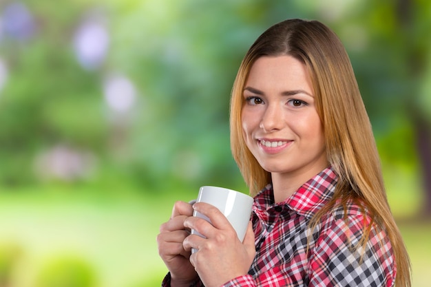 Portrait of a young woman with cup of tea or coffee