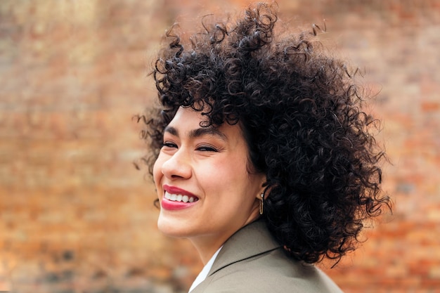 Portrait of a young woman with curly hair laughing