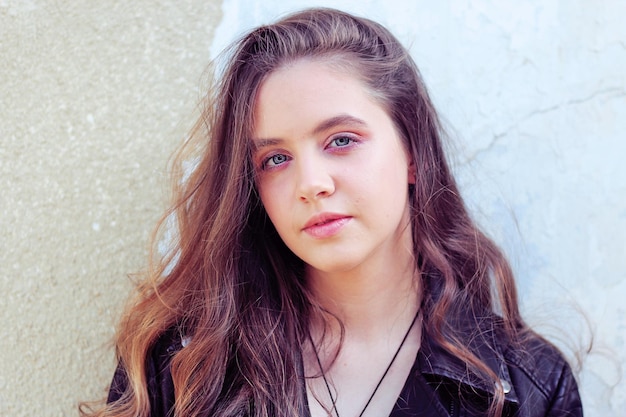 Portrait of a young woman with curly hair in a leather jacket