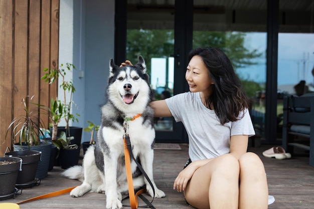 Portrait of young woman with dog on floor at home