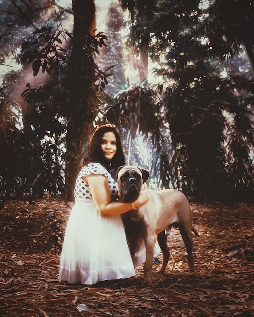 Photo portrait of young woman with dog in forest