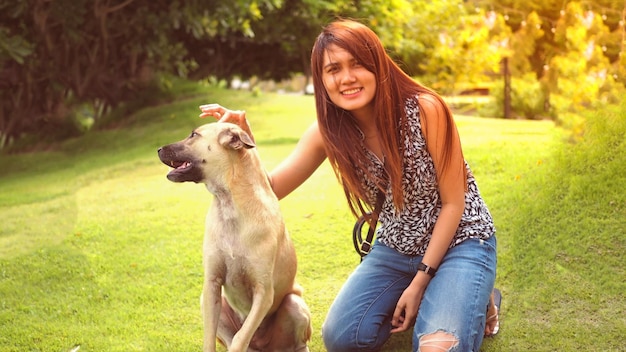 Portrait of young woman with dog in park