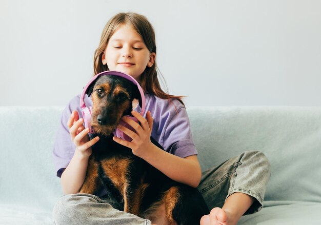 Photo portrait of young woman with dog sitting on bed at home