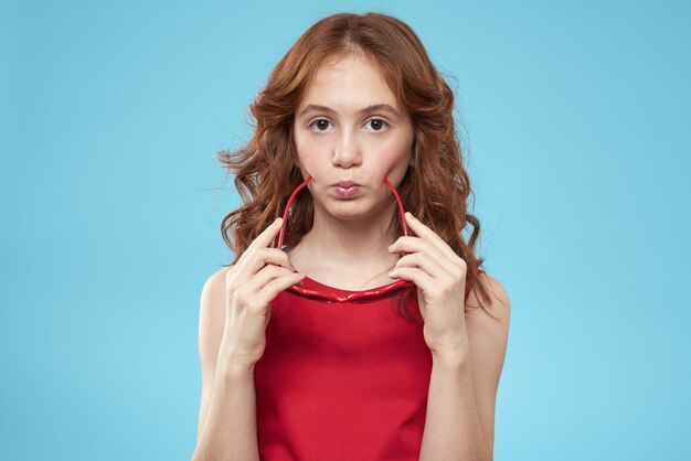 Portrait of young woman with eyes closed standing against blue background