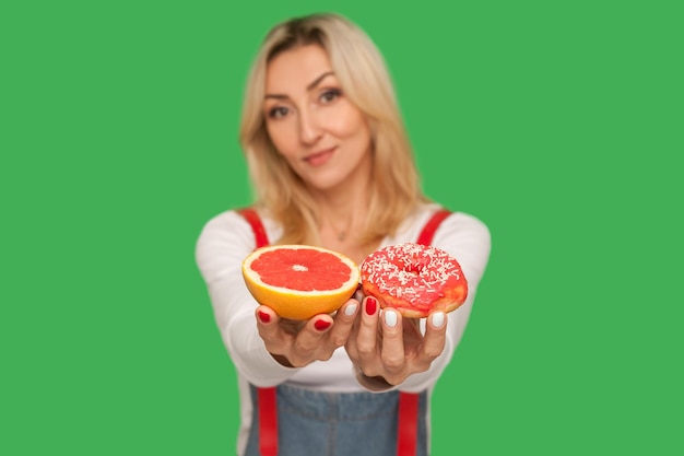 Photo portrait of young woman with fruits against blue background