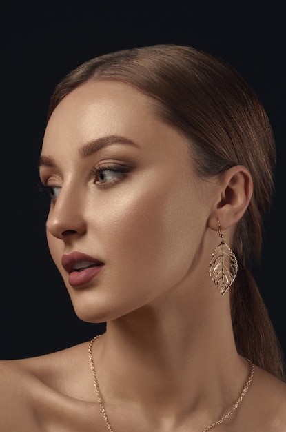 Portrait of young woman with golden earrings