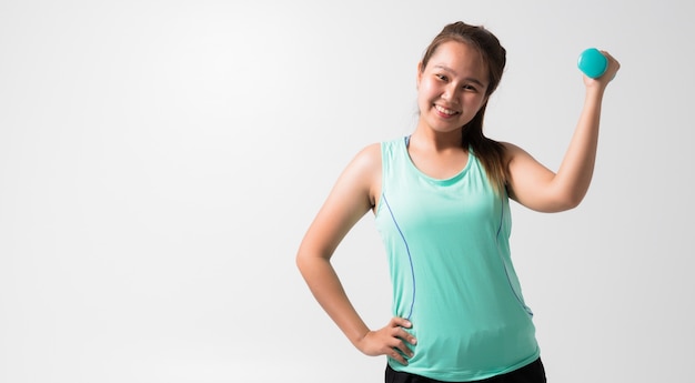 Portrait of a young woman with Green gym clothes and holding weights and doing fitness on a white background.